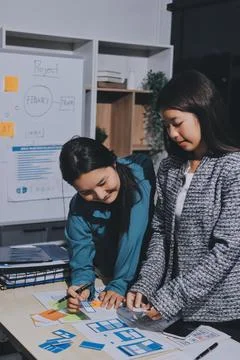 Group of young application developers analyzing uxui mobile app templates d.. Stock Photos