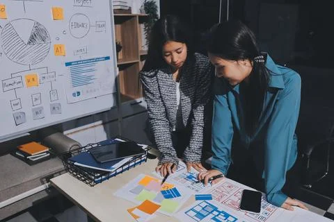 Group of young application developers analyzing uxui mobile app templates d.. Stock Photos