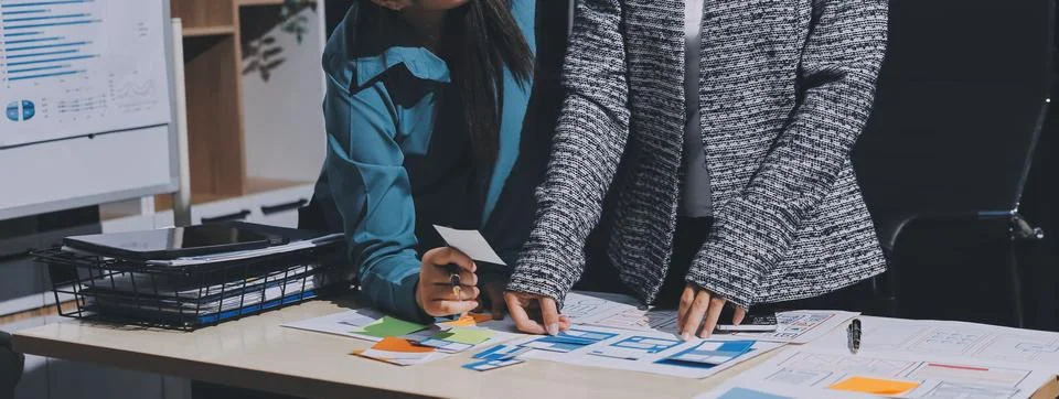 Group of young application developers analyzing uxui mobile app templates d.. Stock Photos