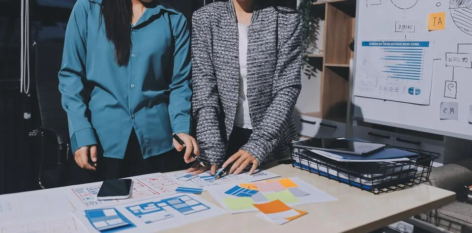 Group of young application developers analyzing uxui mobile app templates d.. Stock Photos