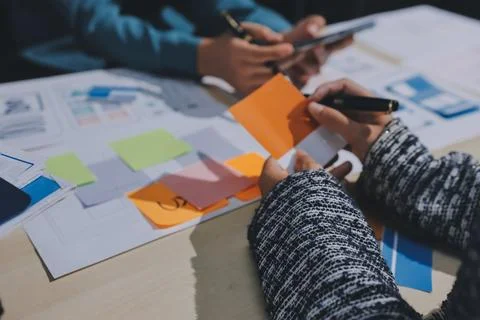 Group of young application developers analyzing uxui mobile app templates d.. Stock Photos