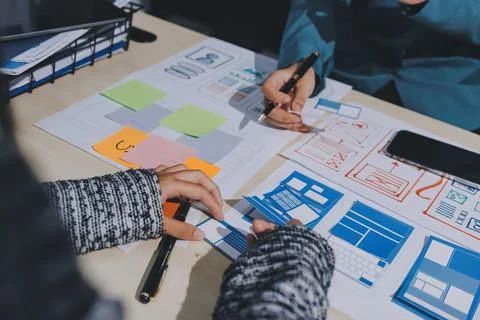 Group of young application developers analyzing uxui mobile app templates d.. Stock Photos