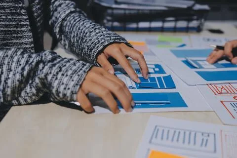 Group of young application developers analyzing uxui mobile app templates d.. Stock Photos