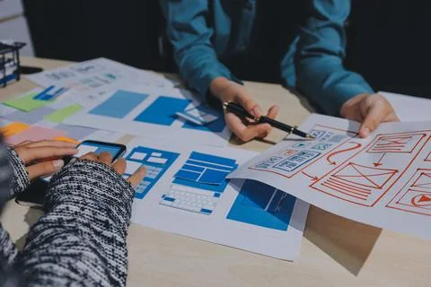 Group of young application developers analyzing uxui mobile app templates d.. Foto stock