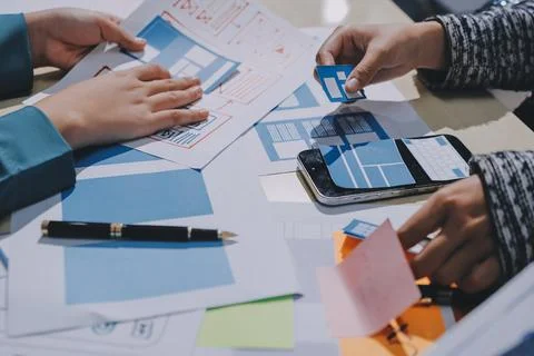 Group of young application developers analyzing uxui mobile app templates d.. Stock Photos