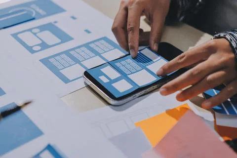 Group of young application developers analyzing uxui mobile app templates d.. Foto stock