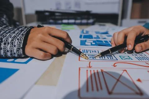 Group of young application developers analyzing uxui mobile app templates d.. Foto stock