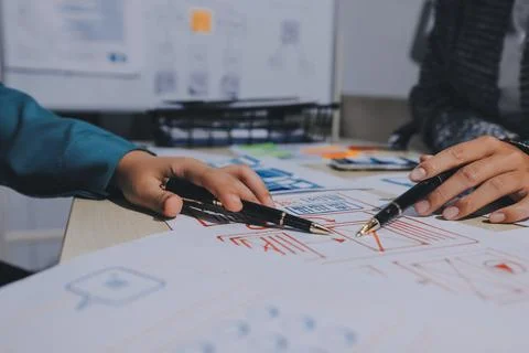 Group of young application developers analyzing uxui mobile app templates d.. Stock Photos