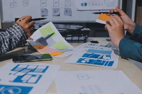 Group of young application developers analyzing uxui mobile app templates d.. Stock Photos