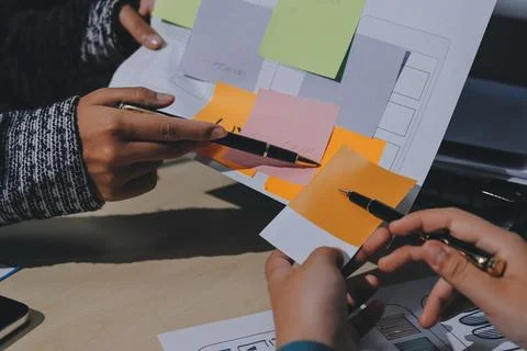 Group of young application developers analyzing uxui mobile app templates d.. Stock Photos