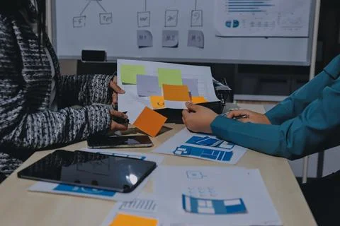 Group of young application developers analyzing uxui mobile app templates d.. Stock Photos