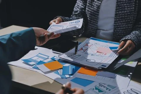 Group of young application developers analyzing uxui mobile app templates d.. Stock Photos