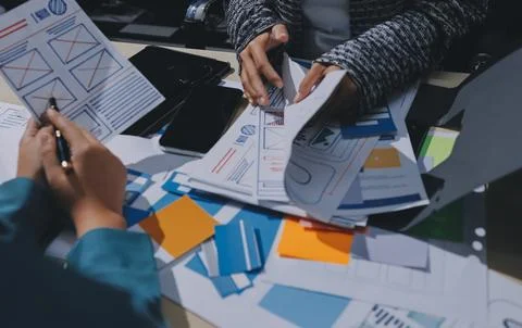 Group of young application developers analyzing uxui mobile app templates d.. Stock Photos