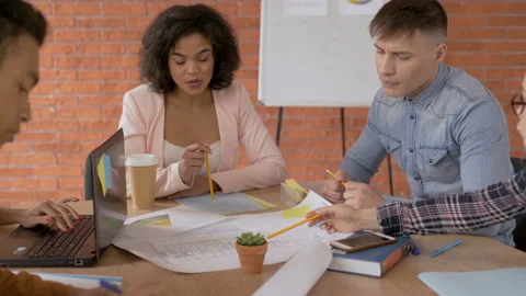 A group of young architects and engineers are working on a building project Stock Footage 108062914