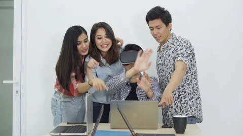 Group of Young Asian Friends Testing Virtual Reality VR Headset Together at.. Stock Footage 337940406