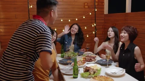 Group of young Asian people party drinking alcohol and eating food sitting at Stock Footage 221421453