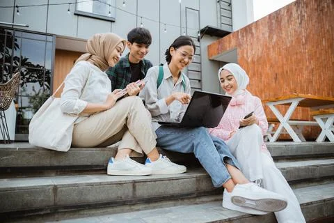 Group of young asian students using laptops sitting on steps Stock Photos