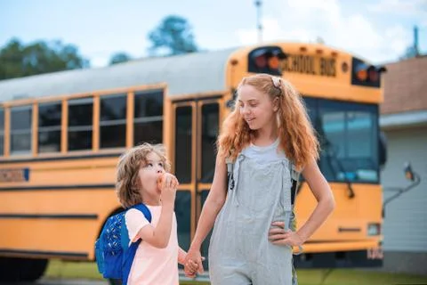 A group of young children getting on the schoolbus. Stock Photos