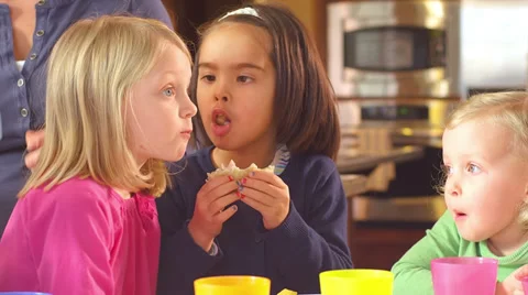 A group of young children sit at a table and party Stock Footage 34003374