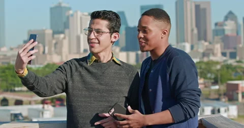 Group of young co-workers hanging out on rooftop patio, two men taking selfie Stock Footage 137268870