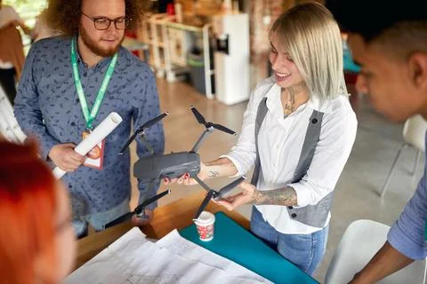 A group of young creative colleagues in the office is excited about a drone t Stock Photos