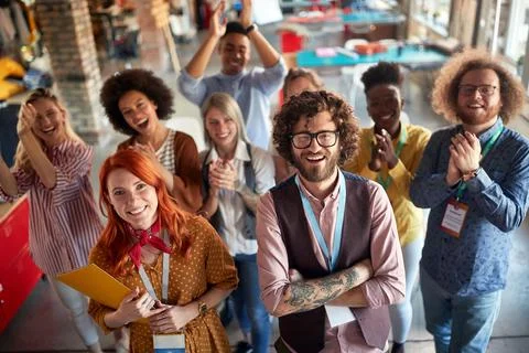 Group of young creative people at work is clapping and yelling while posing f Stock Photos