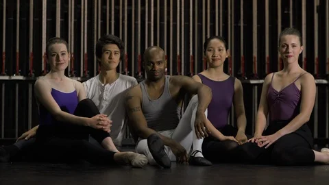 Group of young dancers sitting together on stage smiling at camera. Stock-Footage 88037778
