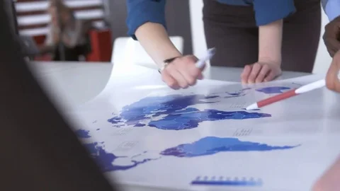 A group of young employees analyzing a world map 動画素材 73861182