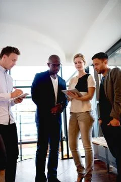 Group of young executives gathered at work. Stock Photos