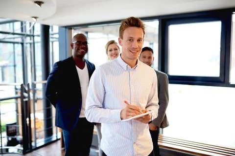 Group of young executives at work smiling and facing camera Stock Photos