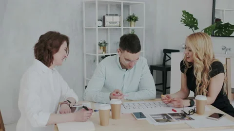 A group of young focused designers of architects are discussing the plan of a Stock Footage 106191029