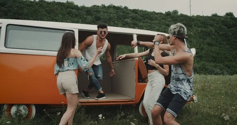 Group of young friends dancing happy at the nature , inside of the retro van and Stock Footage 101057437