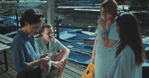 Group of young friends on the dock talking and smling Stock Footage 221318342