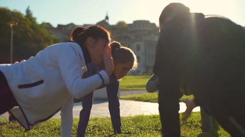 Group of young friends doing the plank exercise and giving high five slow motion Stock Footage 70967363