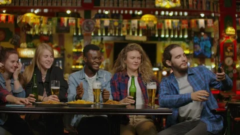 Group Of Young Friends Drinking And Laughing In A Bar. Stock Footage 115070036