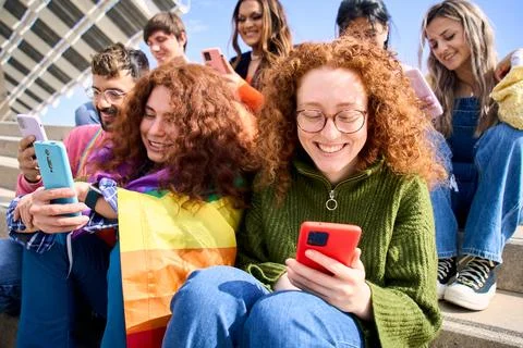 Group young friends watching mobile phone and celebrating gay pride festival day Stock Photos