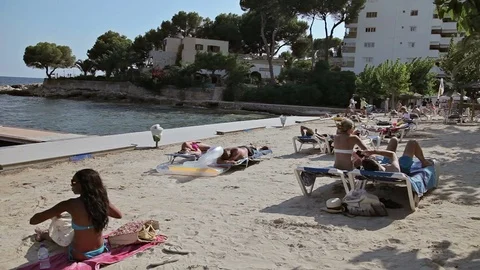 A group of young girls in a bikini sunbathing on the beach. Spanish in a Vídeo Stock 77144802