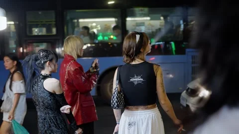 A group of young girls smoke while standing near a high-traffic road. Bangkok Video stock 280207452