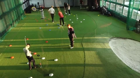 Group of young golfers practicing putting drills indoors on artificial turf Stock Footage 332231775
