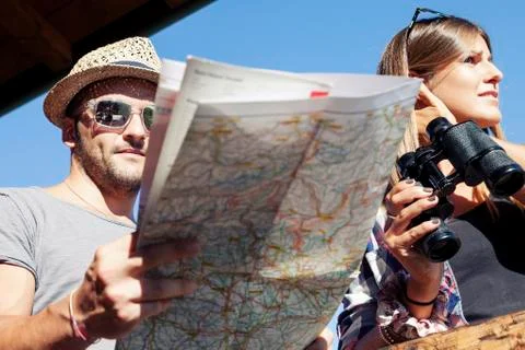 Group of young hikers looking at map in the mountain Stock Photos