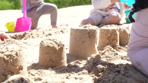Group of young kids together making sand towers on beach during sunny family Vidéo 335839396