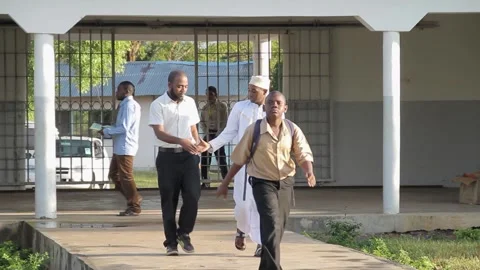 A group of young male students in tan school uniforms and backpacks walking Stock Footage 345409952