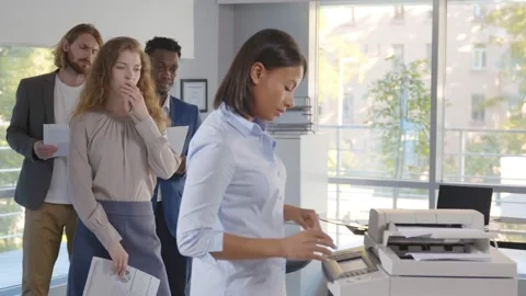 Group of young managers standing in queue for copier at office Video stock 156904808