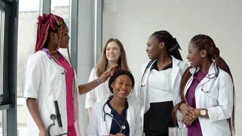 A group of young medics of different races sitting and standing at a table are Stock Footage 148236443