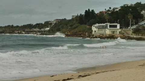 A group of young men jump in large waves at Coogee Sydney slow motion 4K Video stock 272191078