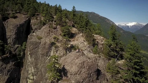 Group Of Young Men Sitting On A Cliff With Big Mountain Views Video stock 78657297