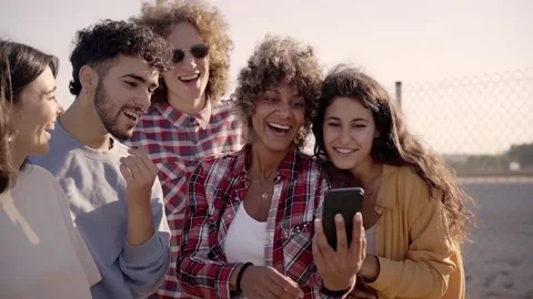 Group of young mixed race people with mobile phones. Excited students using Stock Footage 231254007