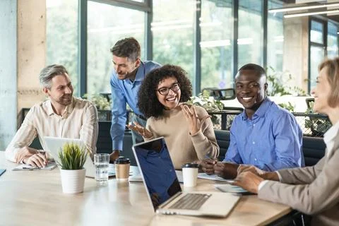 Group of young modern people using modern technologies while working in the.. Stock Photos