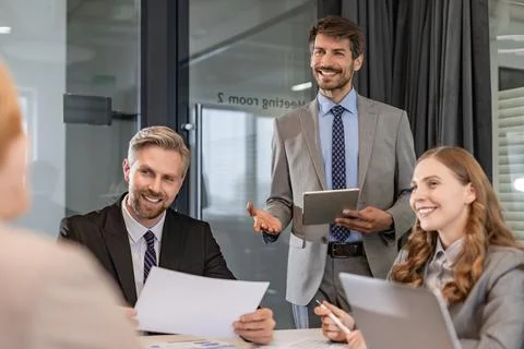 Group of young modern people using modern technologies while working in the m Stock Photos