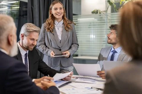 Group of young modern people using modern technologies while working in the.. Stock Photos